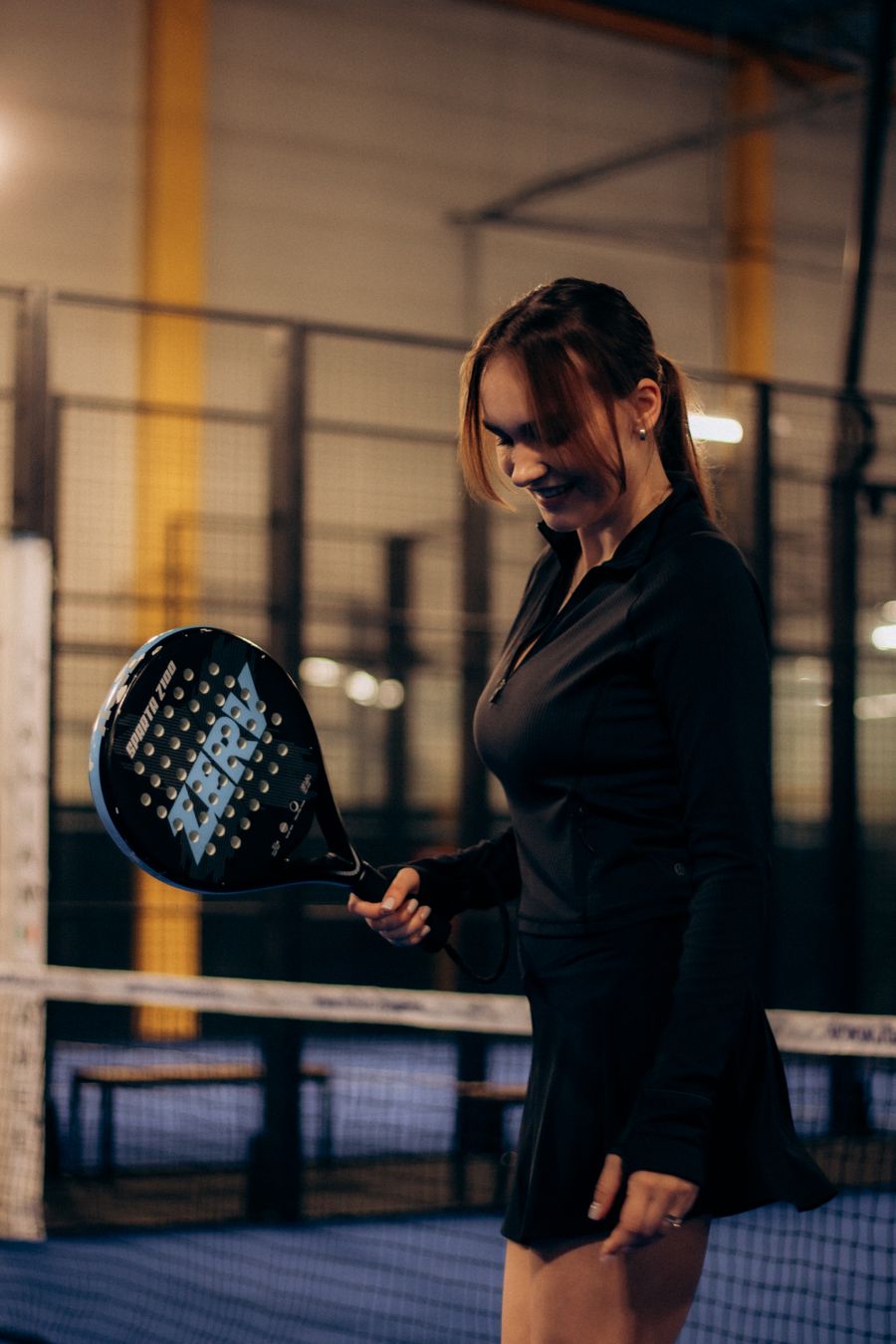 Padel player holding a racket courtside