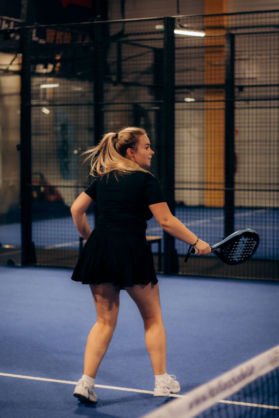 Padel player in a rally seen from behind